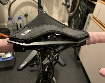 May include: A black and gray bicycle handlebar with a black and gray saddle bag attached to the top. The saddle bag has the word "TOCK" printed on it.
