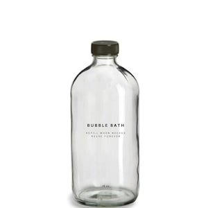 May include: A clear glass bottle with a black lid and a label that reads "BUBBLE BATH REFILL WHEN NEEDED REUSE FOREVER 16 oz".