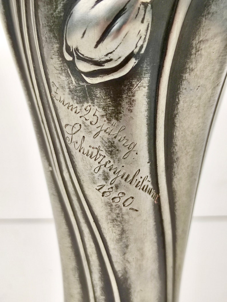 K&ouml;nnte beinhalten: Eine silberne Vase mit Tulpenmotiv und der Inschrift "Zum 25. jahrigen Schutztagjubil&auml;um 1880".