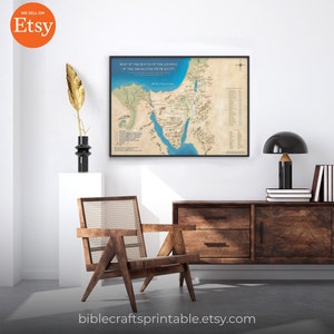 May include: A printable map of the route of the Exodus of the Israelites from Egypt. The map is in a black frame and is hanging on a white wall. The map is surrounded by a brown wooden dresser, a chair, and a lamp.