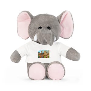 Könnte beinhalten: Ein graues Plüsch-Elefanten-Spielzeug mit großen Ohren, rosa Innenohren und kleinen weißen Stoßzähnen. Der Elefant trägt ein weißes T-Shirt mit einem farbenfrohen Grafikdruck. Das Spielzeug ist für Kinder konzipiert.