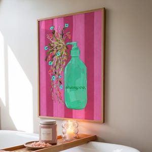 May include: A framed wall art print featuring a bright green shampoo bottle with a pump dispenser. The bottle has the word shampoo printed on it in dark green. A spray of colorful wildflowers emerges from the pump against a pink striped background.
