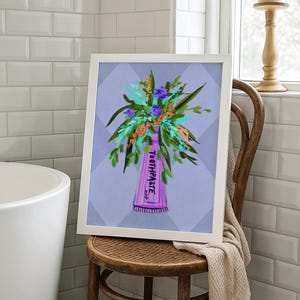 May include: A framed art print featuring a whimsical illustration of a toothpaste tube with a bouquet of flowers. The tube is purple with the word "TOOTHPASTE" printed on it. The flowers are a mix of blue, green, and orange.