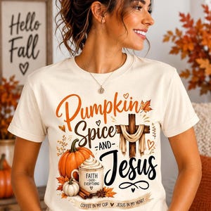 May include: A cream-colored short-sleeve t-shirt featuring a graphic print with the text Pumpkin Spice and Jesus, a wooden cross draped with fabric, a pumpkin, a coffee mug labeled Faith Over Everything, and Coffee in my cup Jesus in my heart.