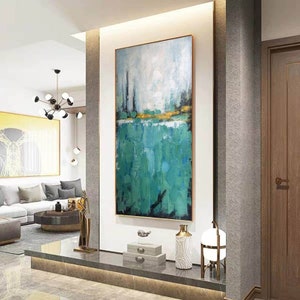 May include: Abstract painting with a green and blue color scheme. The painting is framed and hanging on a white wall in a modern home.