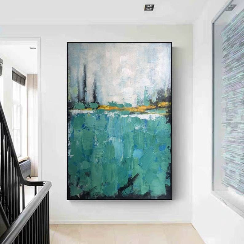 May include: Abstract painting with a green and white color scheme. The painting features a horizontal band of gold paint separating the green and white sections. The green section is made up of thick, textured brushstrokes.