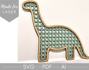 May include: A wooden cutout of a dinosaur with a green woven pattern inside. The cutout is made for laser cutting and is labeled "Made for LASER".