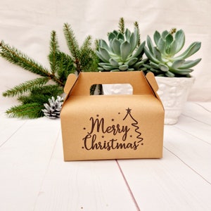 Boîte cadeau de Noël à pignon. Boîte de Noël en papier kraft avec poignée. Contenants d'emballage alimentaire : gâteaux, biscuits, bonbons, chocolat, friandises