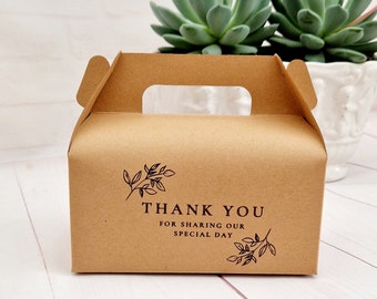 May include: A brown cardboard favor box with a cut-out handle. The box has a black and white floral design and the text "Thank You for sharing our special day".