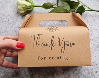 May include: A brown cardboard favor box with a cut-out handle. The box has a simple floral design and the text "Thank You for coming" printed on the front.