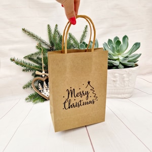 Sac de fête joyeux Noël. Petits ou moyens sacs de Noël en papier kraft brun. Adorables sacs écologiques estampés à la main avec poignées torsadées