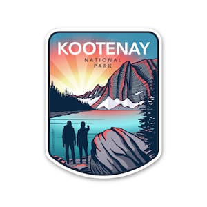 May include: A sticker featuring a scenic view of Kootenay National Park in Canada. The sticker shows a mountain range, a lake, and two figures standing on a rocky shore. The text "KOOTENAY NATIONAL PARK" is printed in white on a blue background.