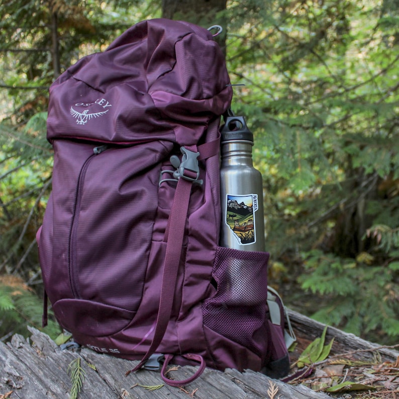 Alberta sticker on a water bottle in the pocket of a backpack