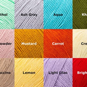 May include: A close-up of twelve skeins of yarn in various colors. Colors include menthol, ash gray, aqua, khaki, pink powder, mustard, carrot, cream, cappuccino, lemon, light lilac, and bright red. Each skein has a label with the color name.