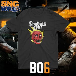 May include: Black t-shirt with a red skull graphic and the text "Shadow Spire" in a gothic font. The skull is surrounded by yellow lightning bolts. The number "B06" is printed in orange.
