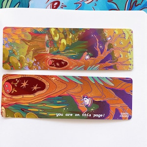 May include: Two colorful bookmarks with a whimsical forest scene. The top bookmark features a large tree with glowing mushrooms and the text "you are on this page!" The bottom bookmark shows a close-up of the tree trunk with a small creature peeking out.