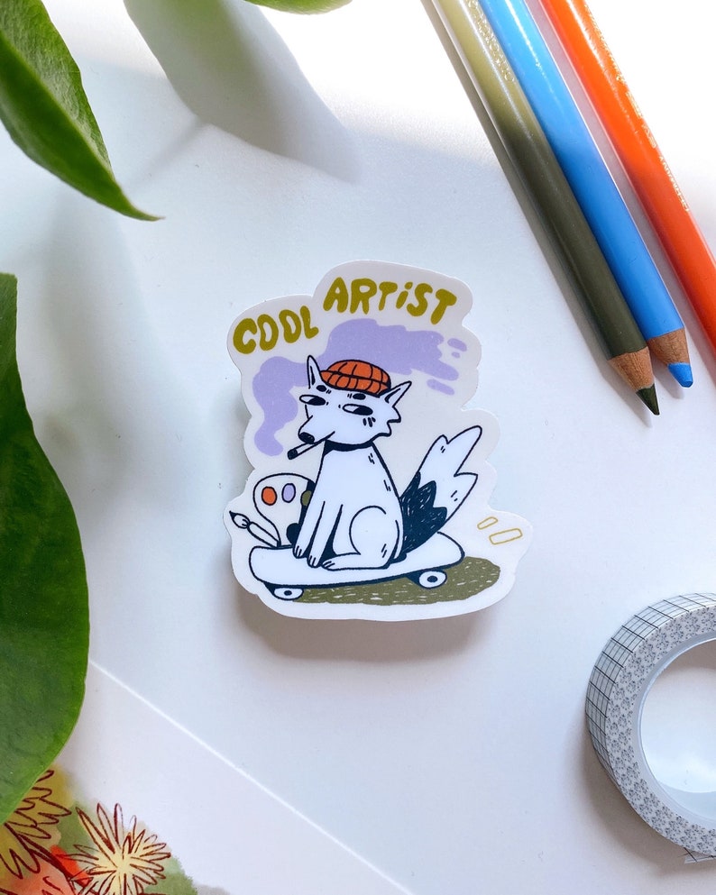 Puede incluir: Un perro blanco con un sombrero rojo y naranja, sosteniendo un pincel y una paleta, est&aacute; montando un monopat&iacute;n. El perro tiene una nube de humo p&uacute;rpura detr&aacute;s y el texto "COOL ARTIST" est&aacute; por encima del perro.