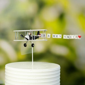 Airplane Wedding Cake Topper with Custom banner Mr. & Mrs. Marriage cute unique honeymoon figurines at the helm of the plane.