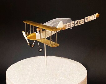 Gold Airplane Wedding Cake Topper with Custom banner Mr. & Mrs. Marriage cute unique honeymoon figurines at the helm of the plane.