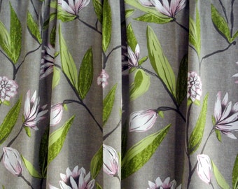 Könnte beinhalten: Graue Vorhänge mit einem floralen Muster aus weißen und rosa Magnolienblüten und grünen Blättern.