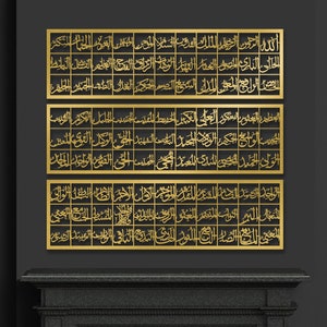 May include: Three gold metal wall decor pieces with Arabic calligraphy in a black and gold room with a fireplace and two chairs.