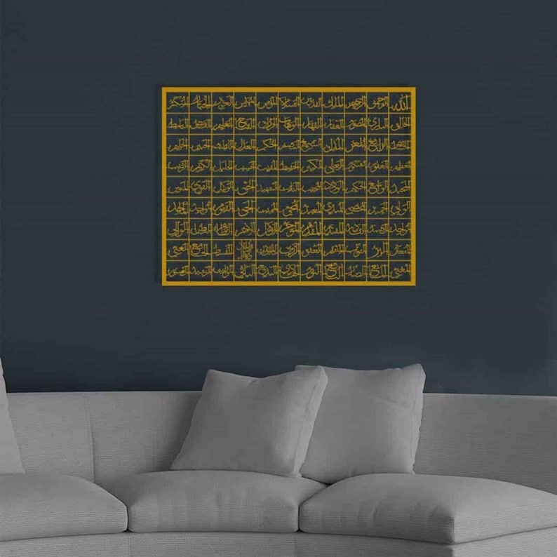 May include: A gold framed wall art piece with Arabic calligraphy in a grid pattern. The art is hanging on a dark gray wall above a gray couch.