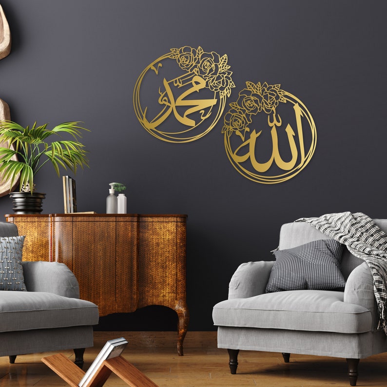 K&ouml;nnte beinhalten: Zwei goldene Wanddekorationen aus Metall mit floralen Akzenten. Das linke St&uuml;ck zeigt das arabische Wort "Muhammad" und das rechte St&uuml;ck zeigt das arabische Wort "Allah".