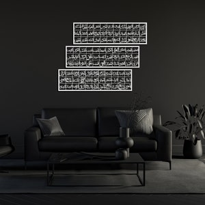 May include: Three black and white framed pieces of Islamic calligraphy art hanging on a black wall above a black leather sofa with black throw pillows.