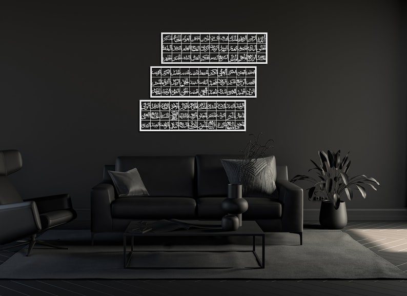 May include: Three black and white framed pieces of Islamic calligraphy art hanging on a black wall above a black leather sofa with black throw pillows.