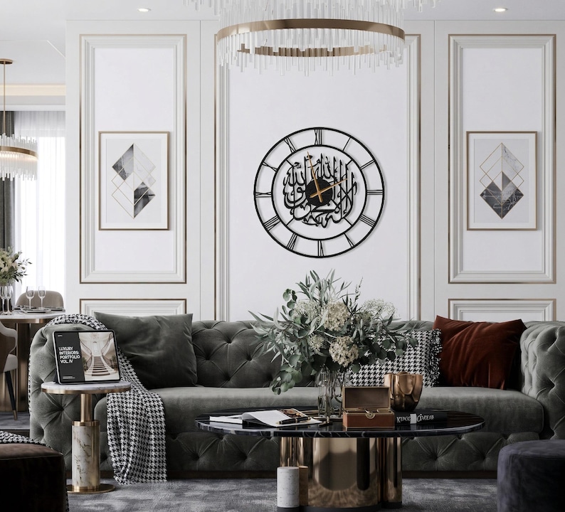K&ouml;nnte beinhalten: Ein Wohnzimmer mit einem grauen Sofa, einem runden Couchtisch und einer dekorativen Wanduhr mit arabischer Kalligraphie. Der Raum ist mit gerahmter Kunst, einem Blumenarrangement und einem Beistelltisch aus Marmor dekoriert.