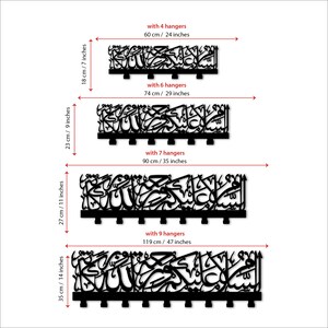 May include: Four different sizes of a black calligraphy wall art piece with hangers. The art piece is a decorative Islamic design with the text "Allah" in Arabic. The sizes are 60 cm, 74 cm, 90 cm, and 119 cm.