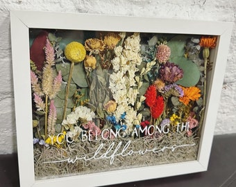May include: A white framed shadow box with dried flowers and greenery. The text "You belong among the wildflowers" is printed on the bottom of the box.