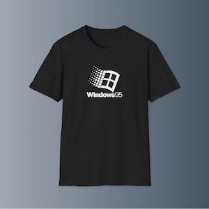 May include: Black crew neck t-shirt featuring the Windows 95 logo in white. The logo includes a stylized flag design with the text "Windows95" below it. The shirt is made of a soft material.