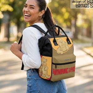 May include: A Winnie the Pooh themed backpack with a tan, black, and red color scheme. The backpack features illustrations of Winnie the Pooh and the text "WINNIE the POOH". The text "This is an original design of BERRY BROTHERS SHOP" is also visible.