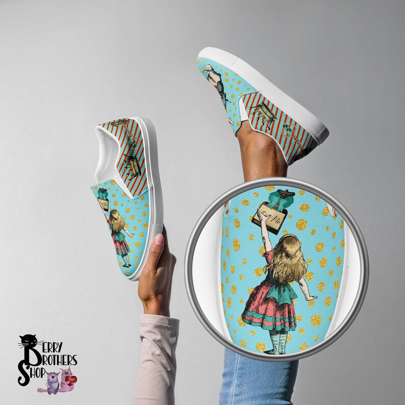 May include: A pair of blue slip-on canvas shoes with a whimsical Alice in Wonderland design. The shoes feature a blue background with white polka dots and a print of Alice holding a sign that says "Eat Me".