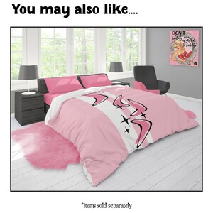 May include: A pink and white bedding set with a retro design featuring boomerangs and starbursts. The set includes a comforter, pillows, and a pink faux fur rug. The text "You may also like..." is at the top.