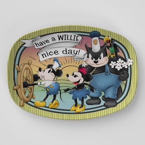 May include: An oval-shaped decorative plate featuring a cartoon scene with Mickey and Minnie Mouse, Pete, and a parrot. The plate has a yellow background with vertical stripes and the text "have a WILLIE nice day!" in a banner.