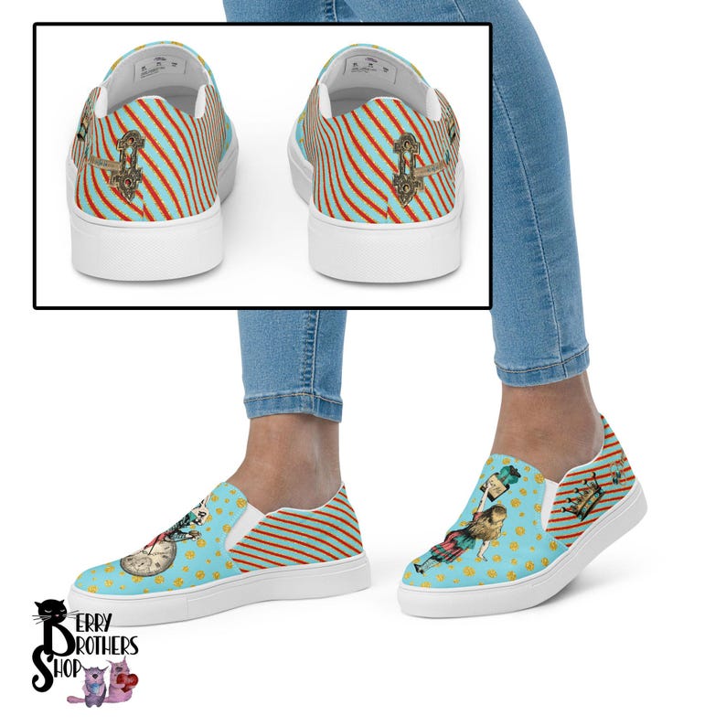 May include: A pair of blue and white striped slip-on canvas shoes with a whimsical Alice in Wonderland design featuring a clock, a crown, and a character holding a teacup. The shoes have a white sole and a blue and white striped pattern on the back.