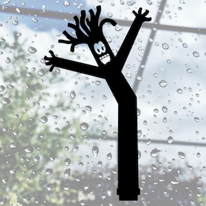 May include: A black inflatable tube man with a goofy expression and wild hair, seen through a window with raindrops.