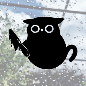 May include: Black cat sticker with large eyes holding a knife. The cat is facing forward with its tail curled behind it.