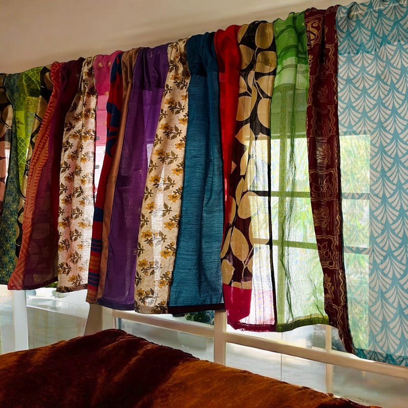 May include: A set of colorful fabric curtains with various patterns and textures. The curtains are hung on a window and are made of a variety of materials, including silk, cotton, and linen.
