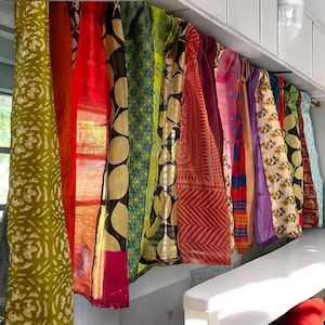 May include: A collection of colorful fabric panels with various patterns and textures, hanging from a white ceiling. The panels are made of silk and cotton and feature a variety of colors, including red, green, blue, purple, and yellow.