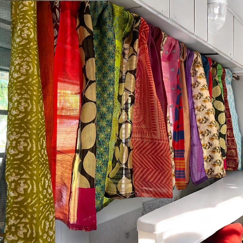 May include: A collection of colorful fabric panels with various patterns and textures, hanging from a white ceiling. The panels are made of silk and cotton and feature a variety of colors, including red, green, blue, purple, and yellow.