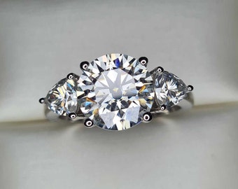 Puede incluir: Un anillo de plata con tres diamantes grandes, claros, redondos y en forma de pera.