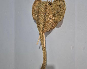 May include: A woven elephant head wall hanging. The elephant is made of natural-colored straw and features large ears, a trunk, and a small flower detail. A loop is attached for hanging.