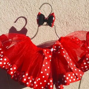 Può includere: Gonna tutu in tulle rosso con pois bianchi e un fiocco nero e rosso.