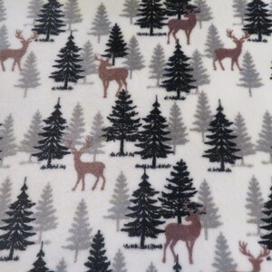 May include: White fabric with a repeating pattern of brown deer and evergreen trees in shades of black and gray. The trees are stylized, and the deer have antlers.