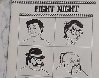 May include: Black and white illustration of a video game box cover for Fight Night, a game for the Commodore 64/128. The cover features four cartoon characters with different facial expressions and hairstyles. The text "Fight Night" is in bold letters at the top of the box. The text "For Commodore 64/128" is at the bottom of the box. The text "Accolade" is in a large font at the bottom of the box.