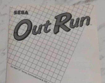 May include: A black and white image of a video game box cover for the game "Out Run" by SEGA. The cover features the game title in a large, stylized font. The text "For Atari ST Series, Commodore 64 & 128, and Amiga" is printed at the bottom of the cover.