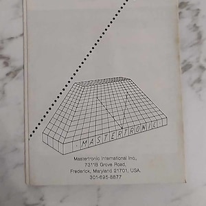 May include: Black and white illustration of a pyramid with the text "MASTERTRONIC" on the side. The text below the illustration reads "Mastertronic International Inc., 7311B Grove Road, Frederick, Maryland 21701, USA. 301-695-8877."
